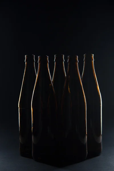 Silhouettes brown glass bottles for beer on a black background — Stock Photo, Image