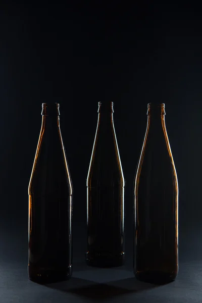 Silhouette bottiglie di vetro marrone per birra su sfondo nero — Foto Stock