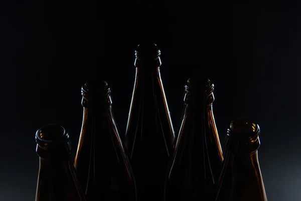 Silhouette bottiglie di vetro marrone per birra su sfondo nero — Foto Stock