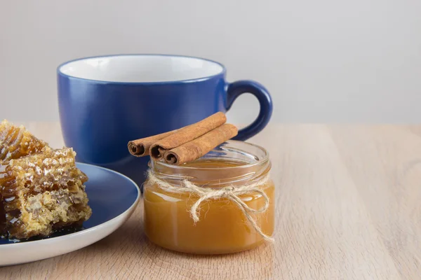 Шматочки золотого медового гребеня на столі з чаєм, лимоном і кіноном — стокове фото