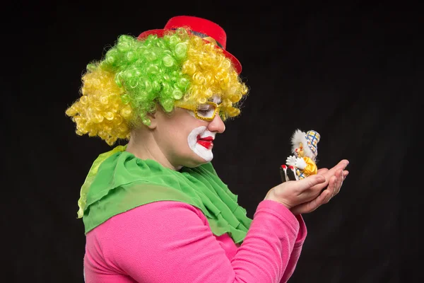 Goede leuke gekrulde clown houden een mooie kleine speelgoed clown — Stockfoto