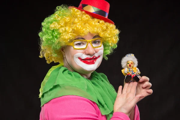 Good fun curly clown holding a beautiful little toy clown — Stock Photo, Image