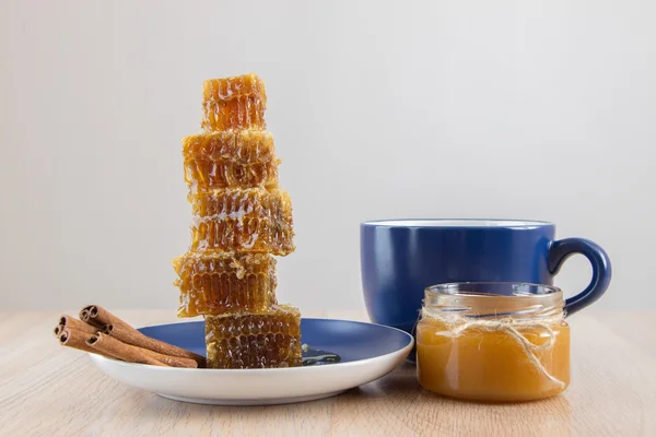 Кусочки золотого медового гребня на столе с чаем, лимоном и корицей — стоковое фото
