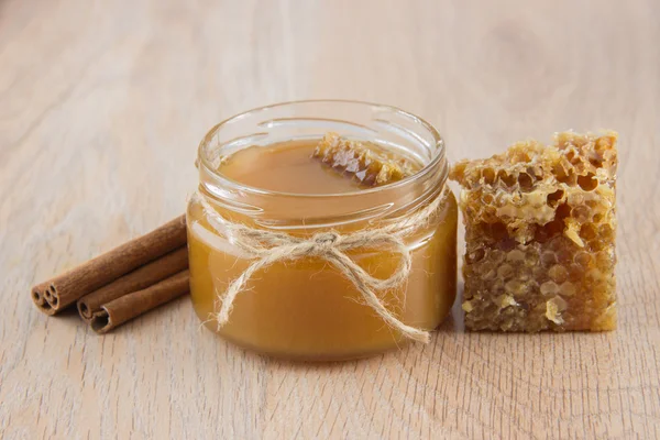 Miel dorada en el peine en un frasco y limón en rodajas amarillas —  Fotos de Stock