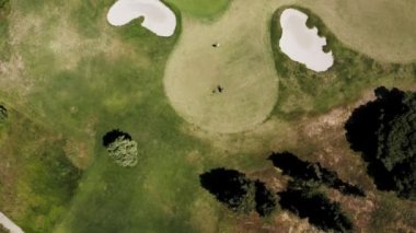 Güneşli bir günde Portekiz 'de bir golf kulübünün hava manzarası. Arka planda yeşil bir golf sahası, tek bir golfçü ve okyanus manzarası var..