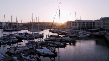Lagos Portekiz marinasında altın saat uçuşu. Limandaki teknelerin üzerinde güzel gün batımı manzarası. 
