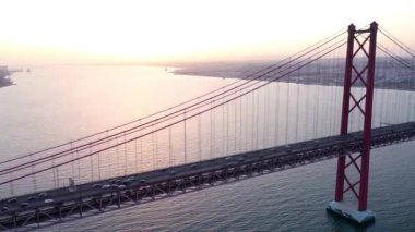 Ponte 25 de Abril ve Cristo Rei 'nin günbatımı görüntüleri. Büyüleyici anıt Lizbon şehrinin muhteşem manzarasıyla filme alınıyor..