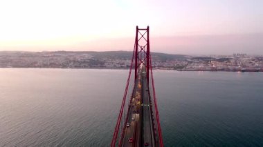 Ponte 25 de Abril ve Cristo Rei 'nin günbatımı görüntüleri. Büyüleyici anıt Lizbon şehrinin muhteşem manzarasıyla filme alınıyor..