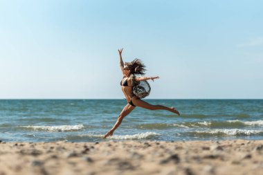Zarif balerin dansı, sahil dansçısından zarif bir atlayış, özgüvenli bale sanatçısı sahil boyunca zarif bir atlayış yapıyor.