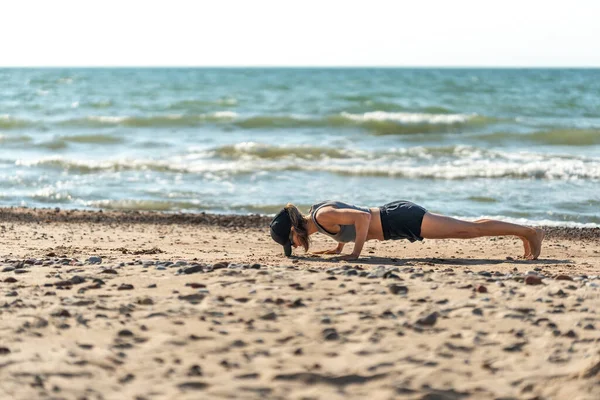 Kumlu plajda tek başına kalasçılık yapan kişi, sakin sahil ortamının ortasında sıkı bir kalas pozisyonunu koruyor.