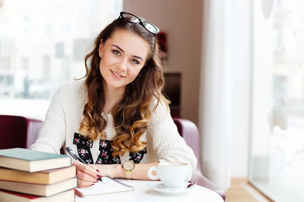 Meisje zit in café — Stockfoto