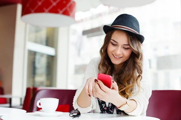 Mädchen mit braunen lockigen Haaren sitzt im Café — Stockfoto