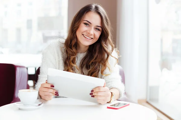 Meisje zit in café met tablet — Stockfoto