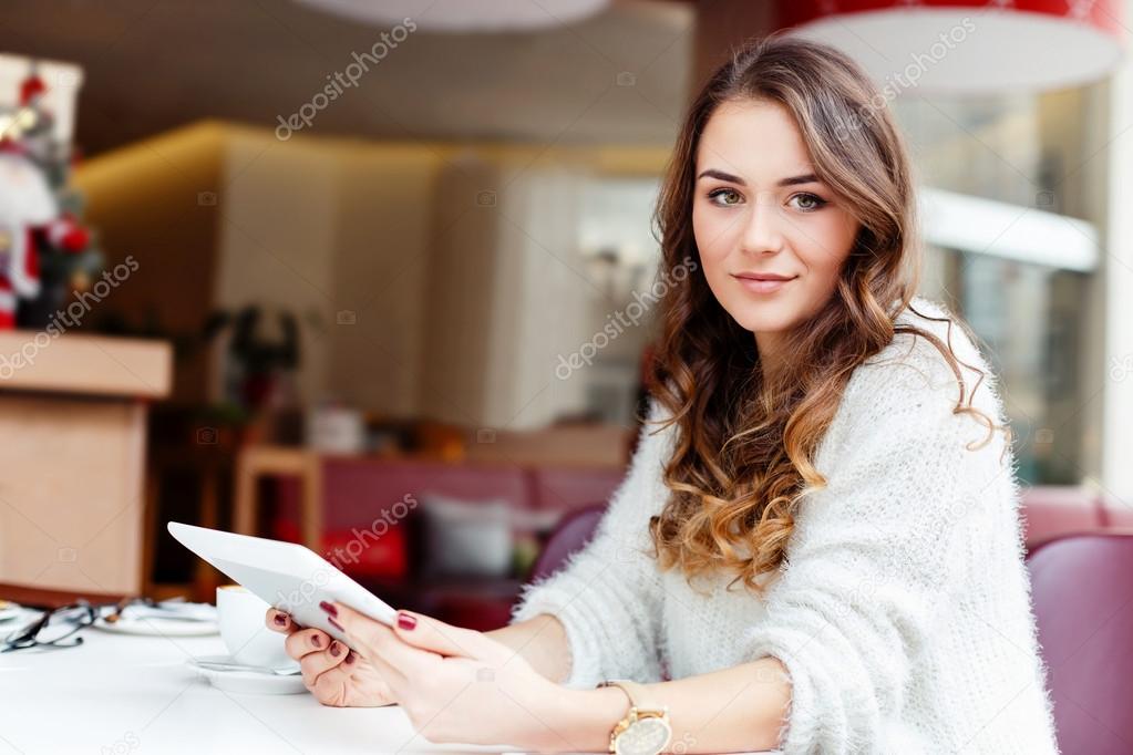 Girl sitting in cafe with tablet