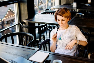 Dizüstü bilgisayar ile kafede oturan kız
