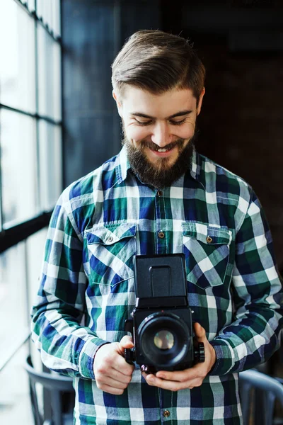 Jovem sorridente com câmera retro — Fotografia de Stock