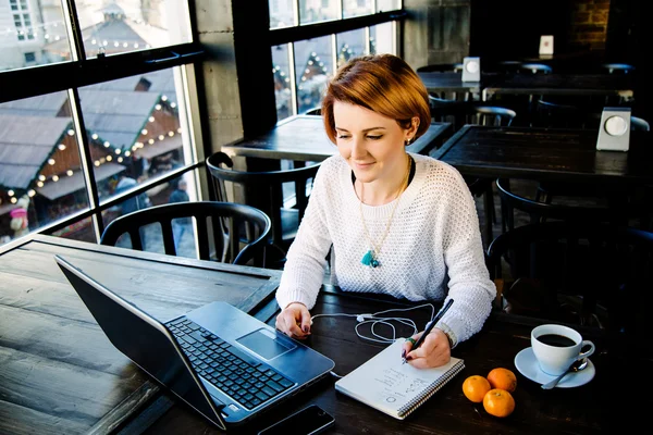 Petite fille aux cheveux courts assise dans un café — Photo