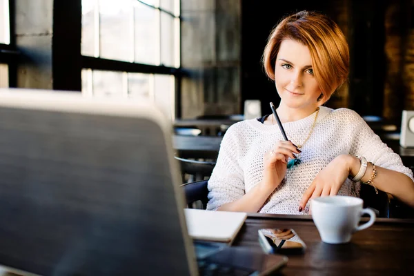 Dziewczyna siedzi w kawiarni z laptopa — Zdjęcie stockowe