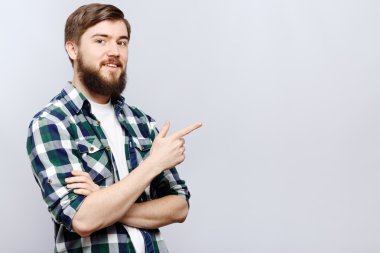 Neşeli genç adam bir şeyler gösteriyor.