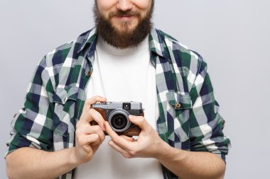 Young happy hipster holding retro camera