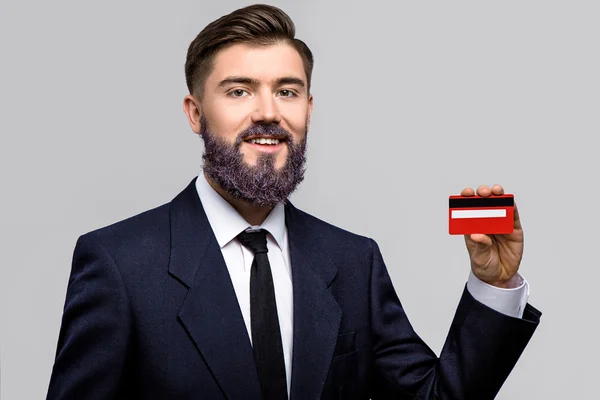 Sorrindo homem posando com cartão de crédito vermelho — Fotografia de Stock