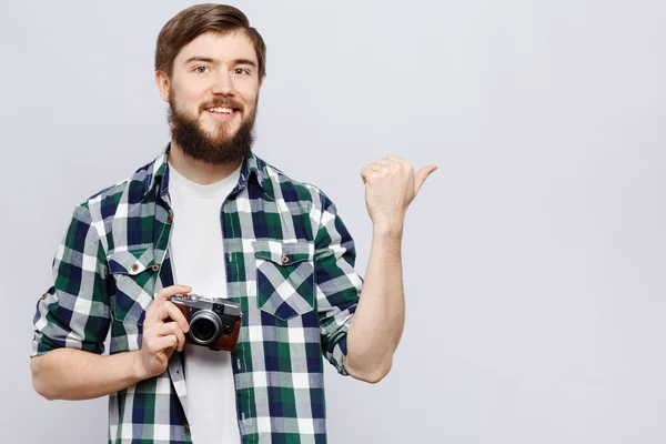 Lachende jonge man toont iets — Stockfoto