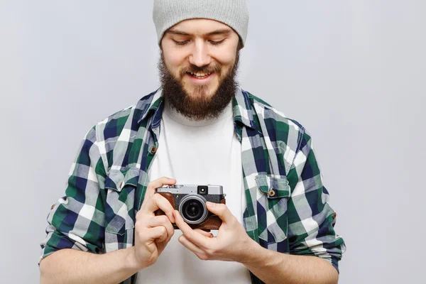 Hymyilevä nuori mies, jolla on retrokamera — kuvapankkivalokuva