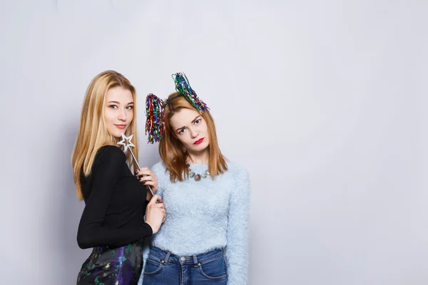 Two female friends at gray studio background — Stock Photo, Image