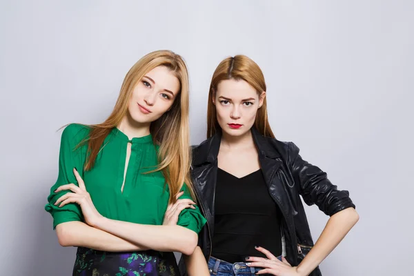 Two female friends at gray studio background — Stock fotografie