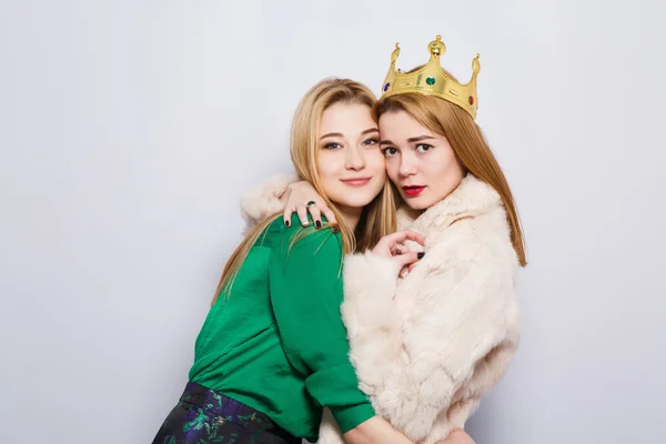 Zwei Freundinnen vor grauem Studiohintergrund — Stockfoto