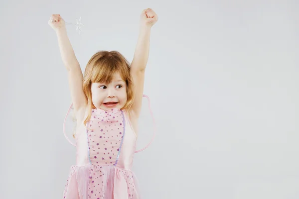 Cheerful little girl puts her hands up