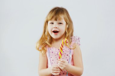 Cheerful girl posing with colorful candy