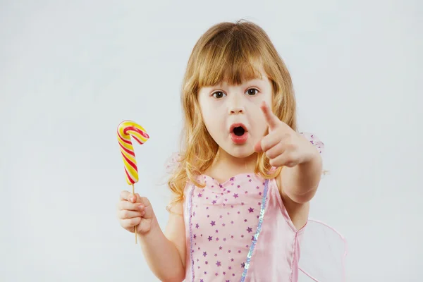 Surprised girl holding colorful candy — Stock Fotó