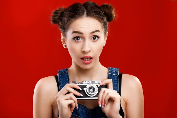 Förvånad kvinna som innehar retro kamera — Stockfoto
