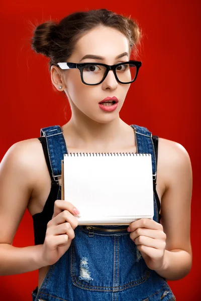 Confused pretty girl holding notebook — Zdjęcie stockowe