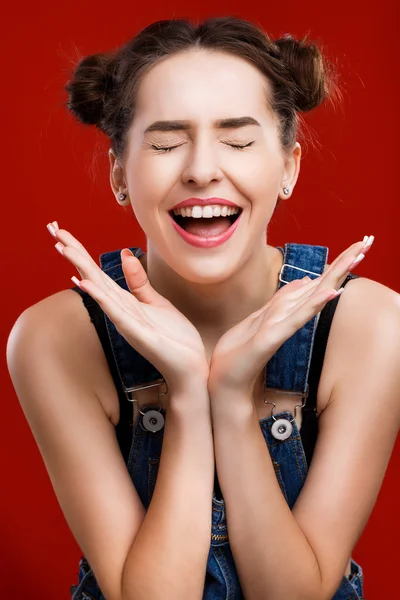 Schönes Mädchen lacht auf rotem Hintergrund — Stockfoto