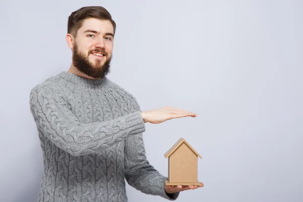 Hombre sosteniendo pequeña casa de madera — Foto de Stock