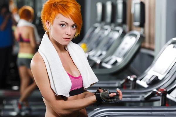 Jolie fille en forme avec des cheveux courts rouges dans la salle de gym — Photo