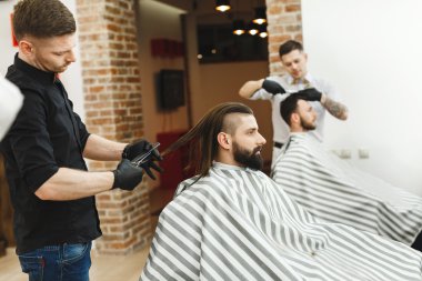 Berberler istemcileri için saç kesimi yapıyor