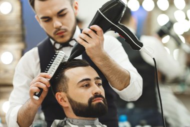 Koyu saçlı Kuaför bir saç kesimi yapıyor