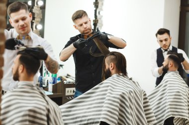 Barbers doing haircuts for clients clipart