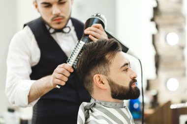 Koyu saçlı Kuaför bir saç kesimi yapıyor