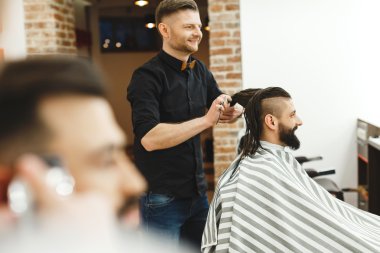 Adam siyah saçlı bir saç kesimi yapıyor