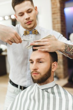 Adam siyah saçlı bir saç kesimi yapıyor