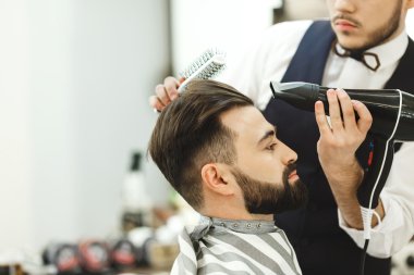 Koyu saçlı Kuaför bir saç kesimi yapıyor