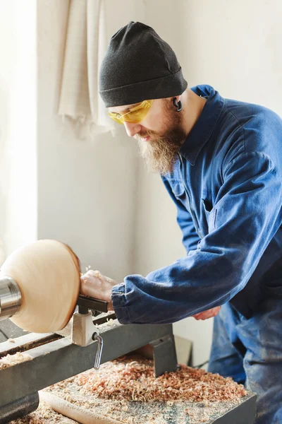 Un hombre que trabaja con instrumentos de talla de madera — Foto de Stock