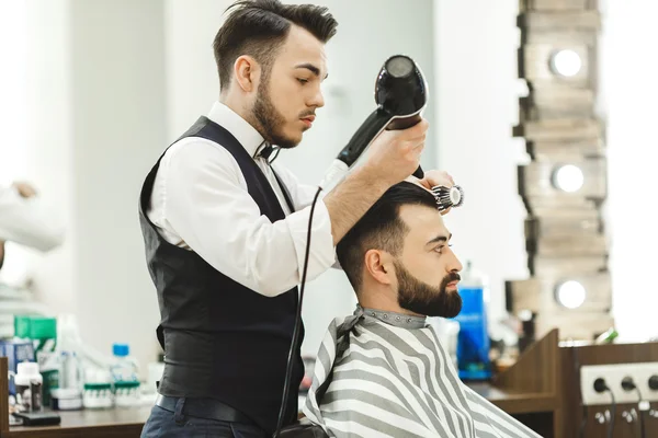 Dark haired barber doing a haircut — Stock Photo, Image