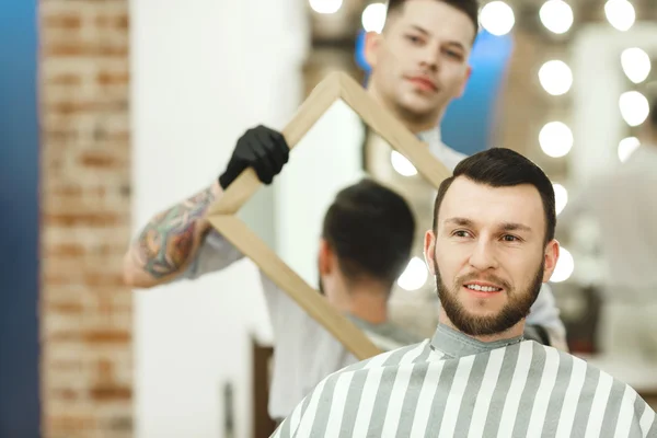 Barbeiro segurando um espelho para o cliente — Fotografia de Stock