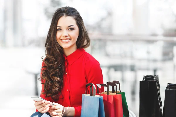 Chica sonriente sentada en el centro comercial —  Fotos de Stock