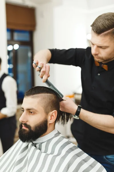 Dark haired barber doing a haircut — Stock Photo, Image